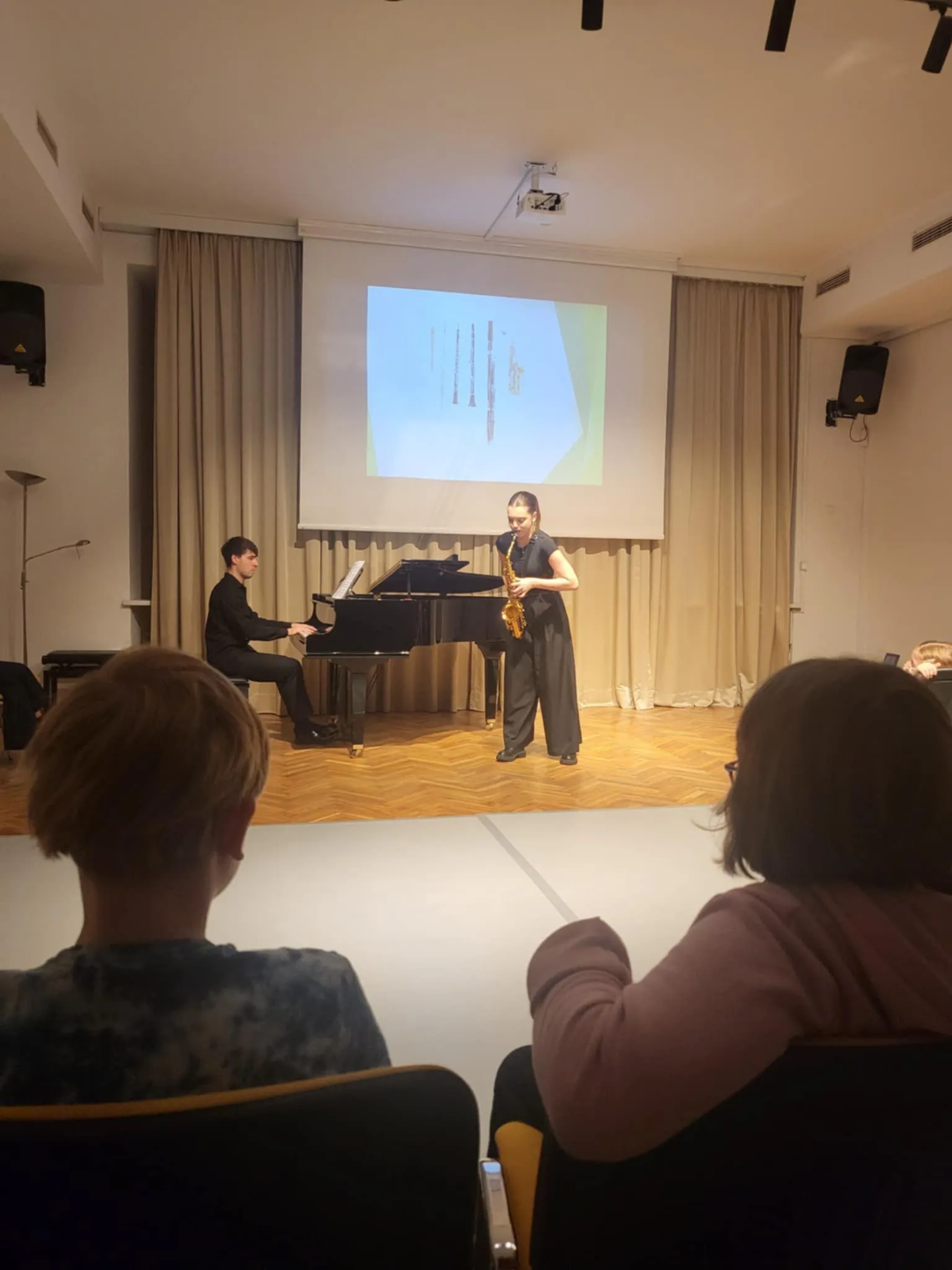 Uczniowie słuchają repertuaru muzycznego na żywo 