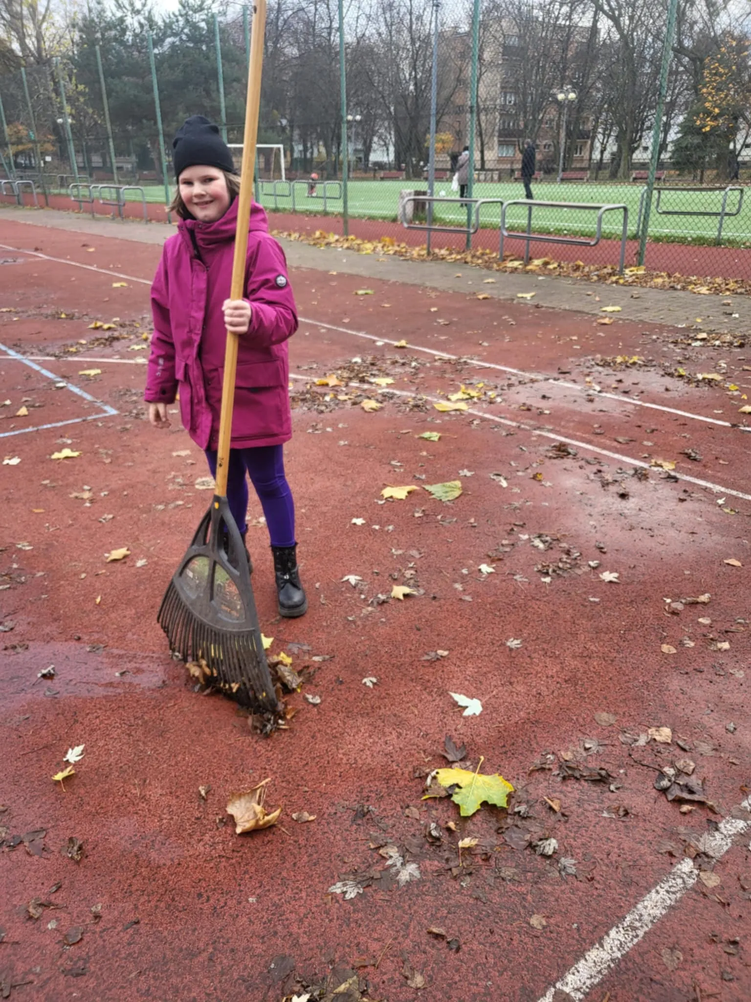 Uczennica grabi liście 