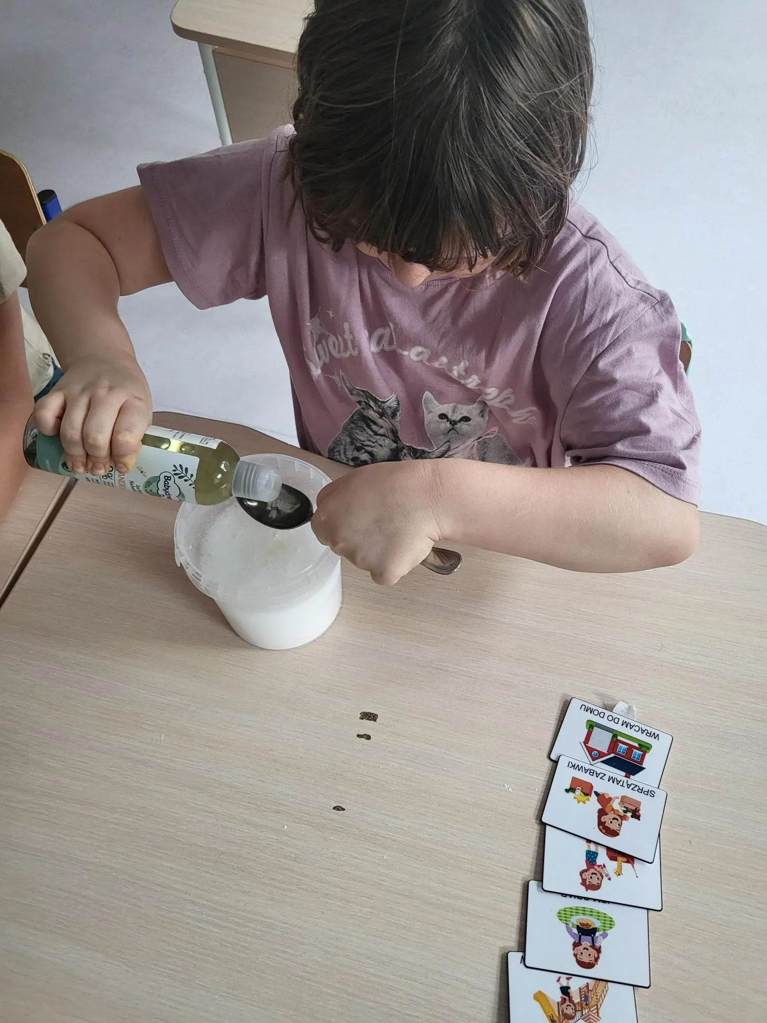 Uczennica odmierza składniki do wykonania kuli do kąpieli 