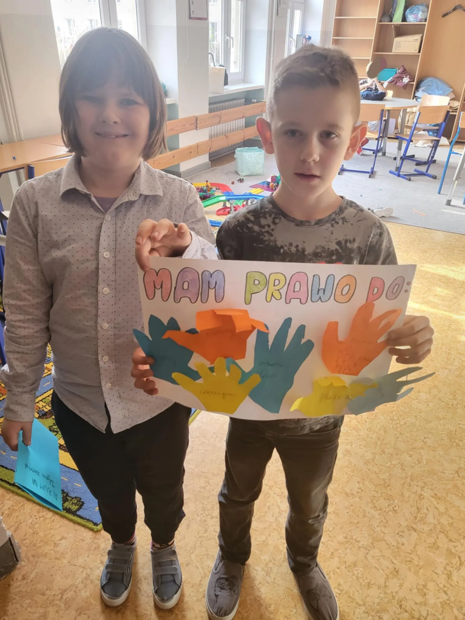 Uczniowie z wspólnie wykonaną pracą plastyczną