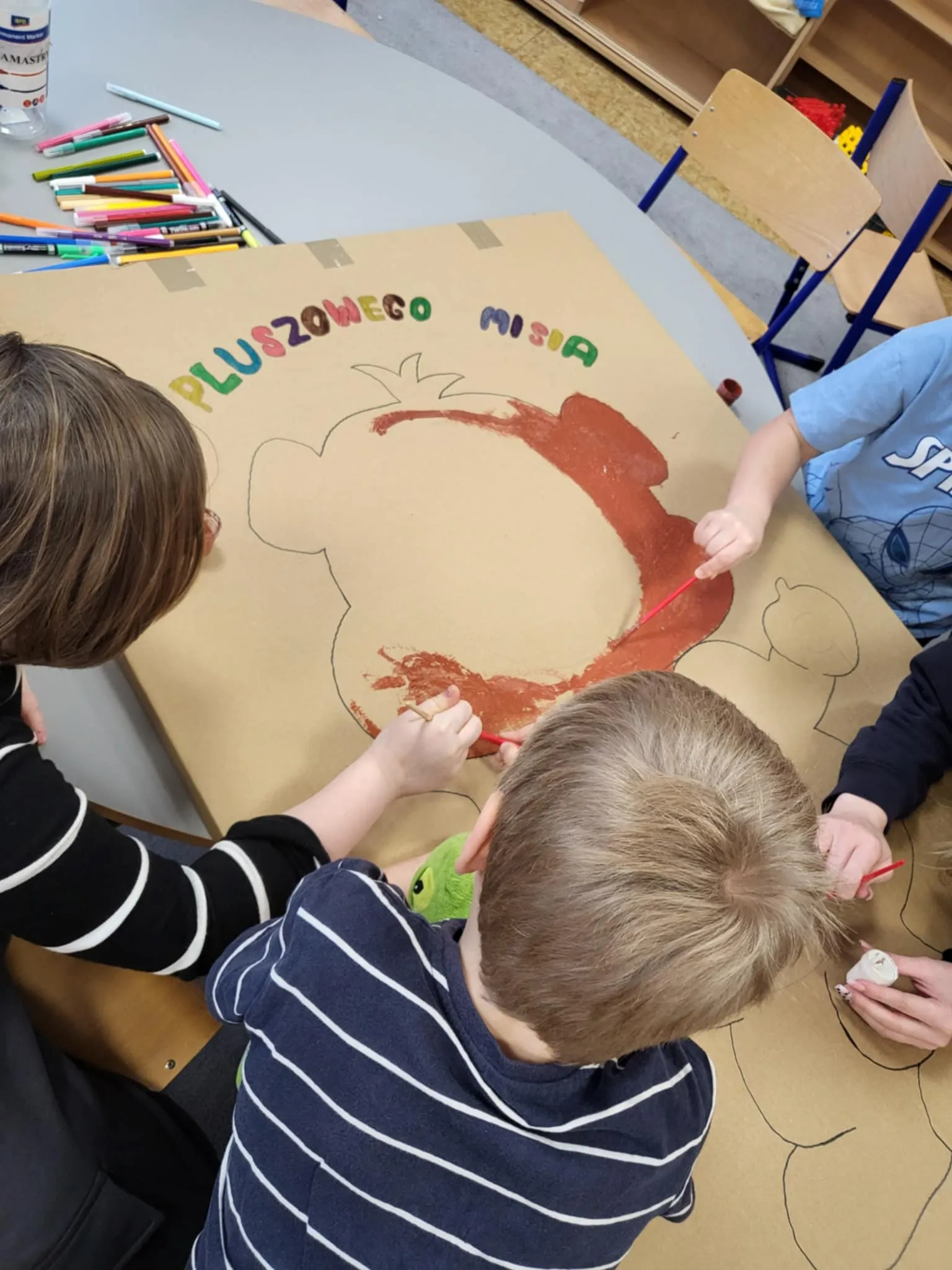 Dzieci wykonują misiową fotobudkę 