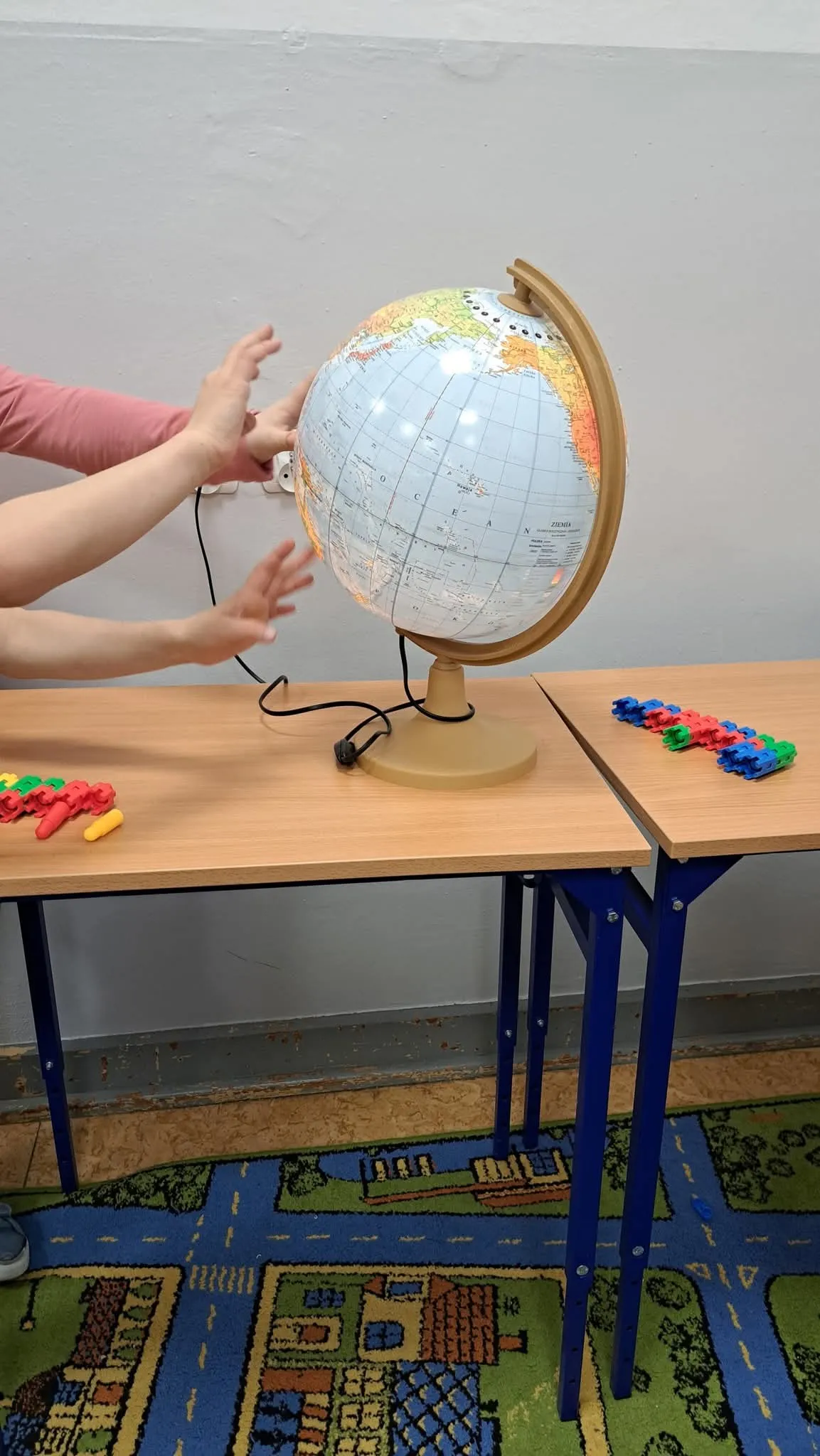 Uczniowie korzystają z globusa podczas zajęć