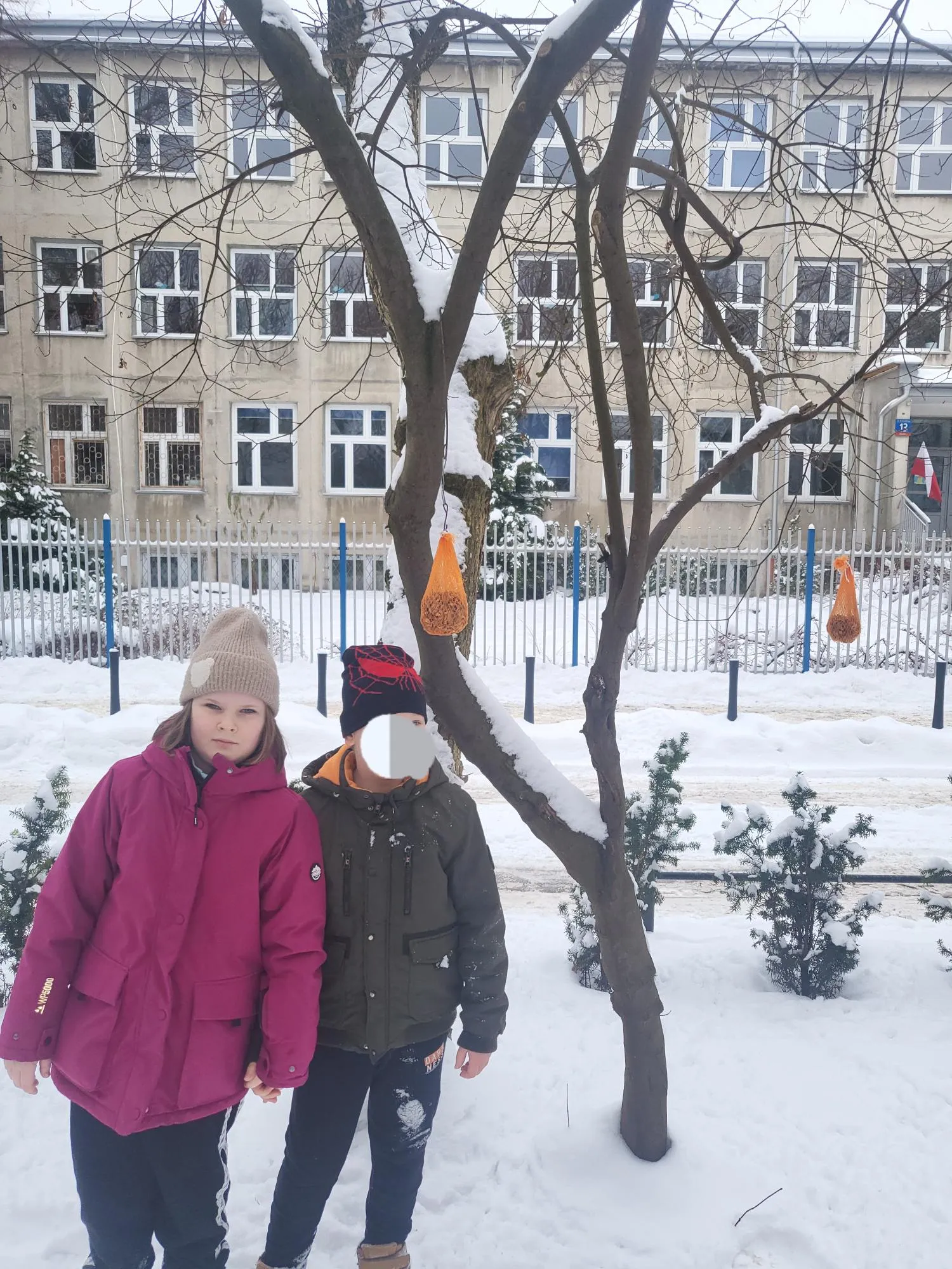 Uczniowie dokarmiają ptaki zimą