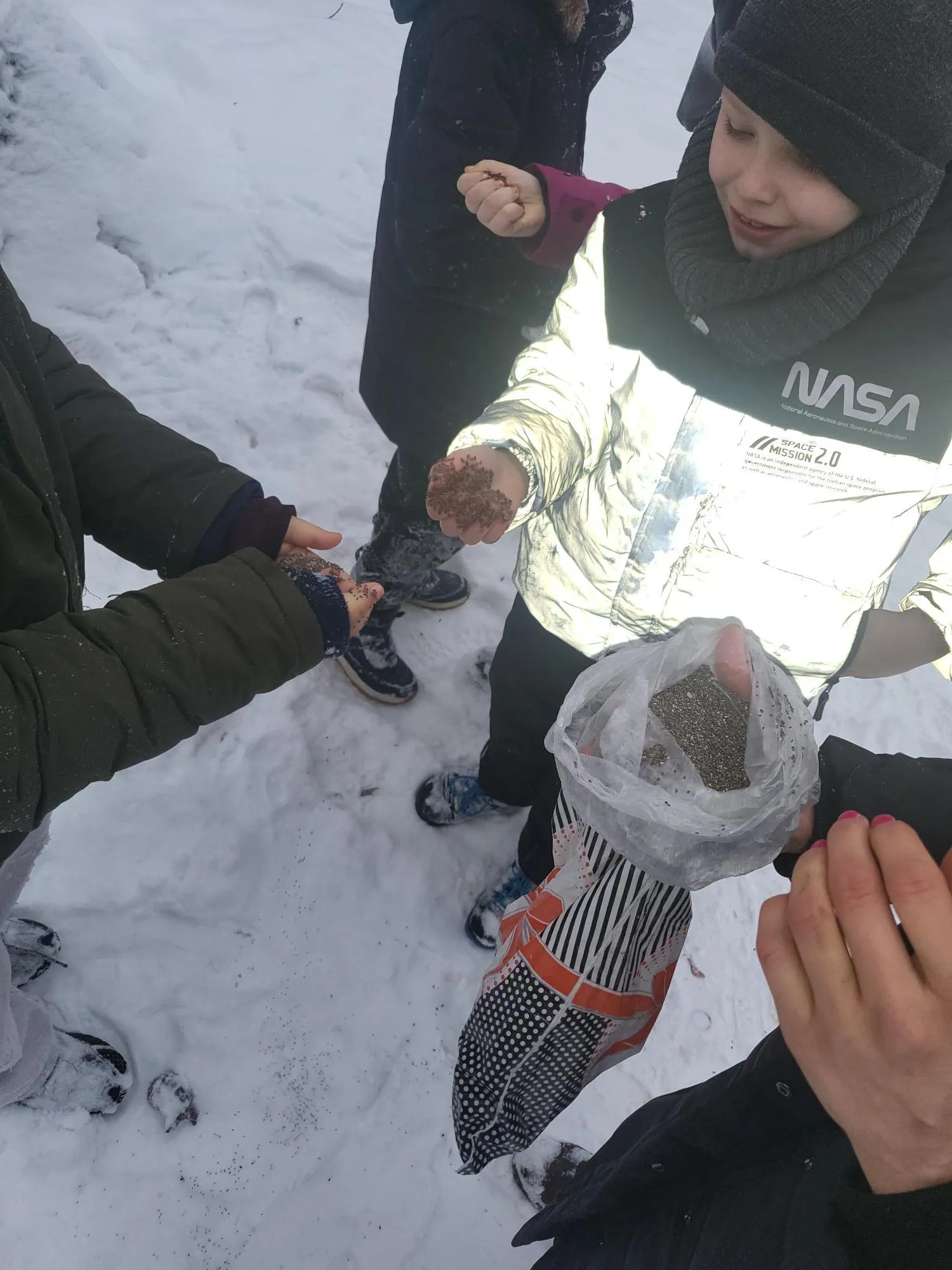 Uczniowie dokarmiają ptaki zimą