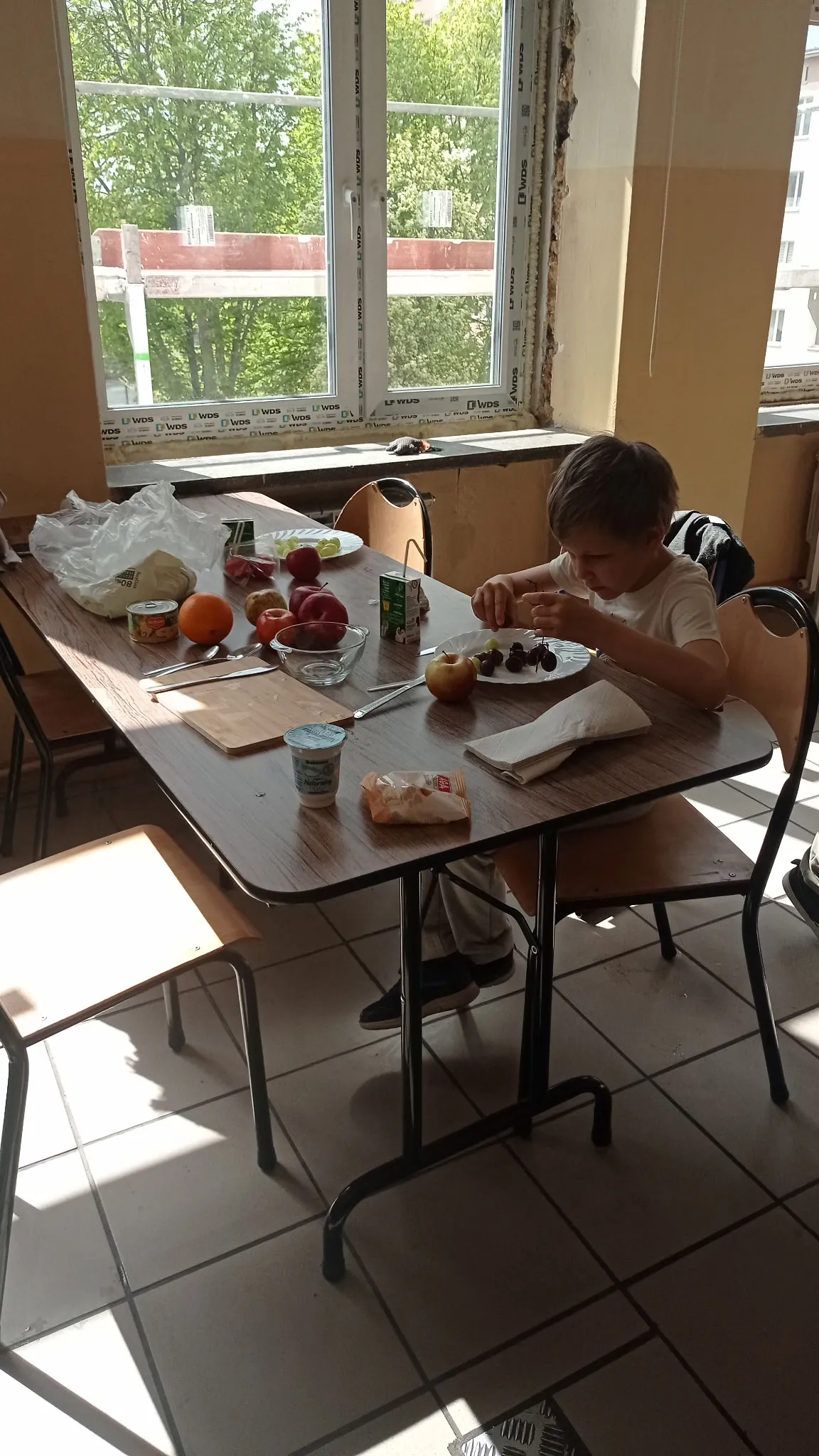uczniowie wykonują sałatkę owocową 